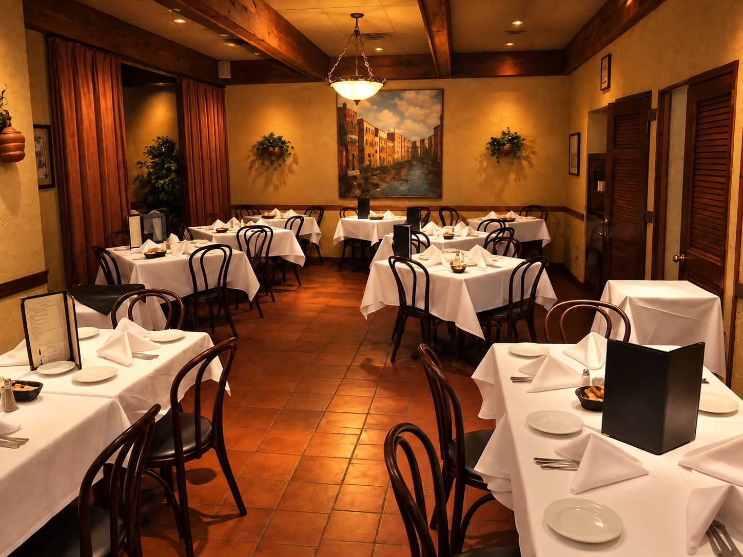 Gino's dining room at night, candlelit tables beneath a Venice mural